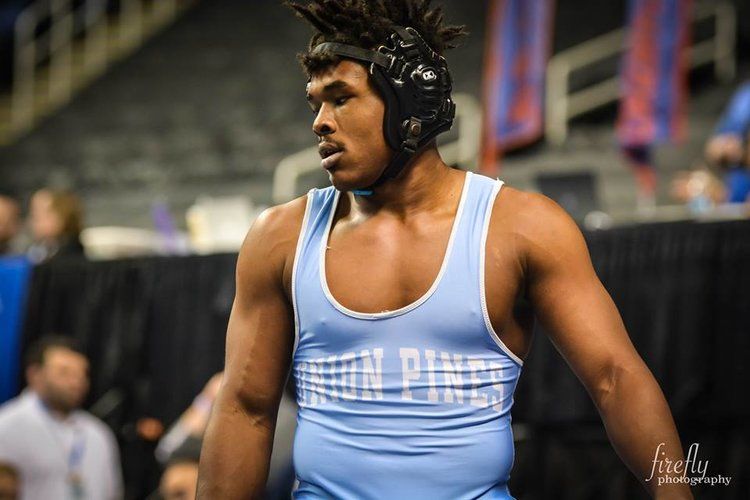 Athlete wearing wrestling headgear on mat