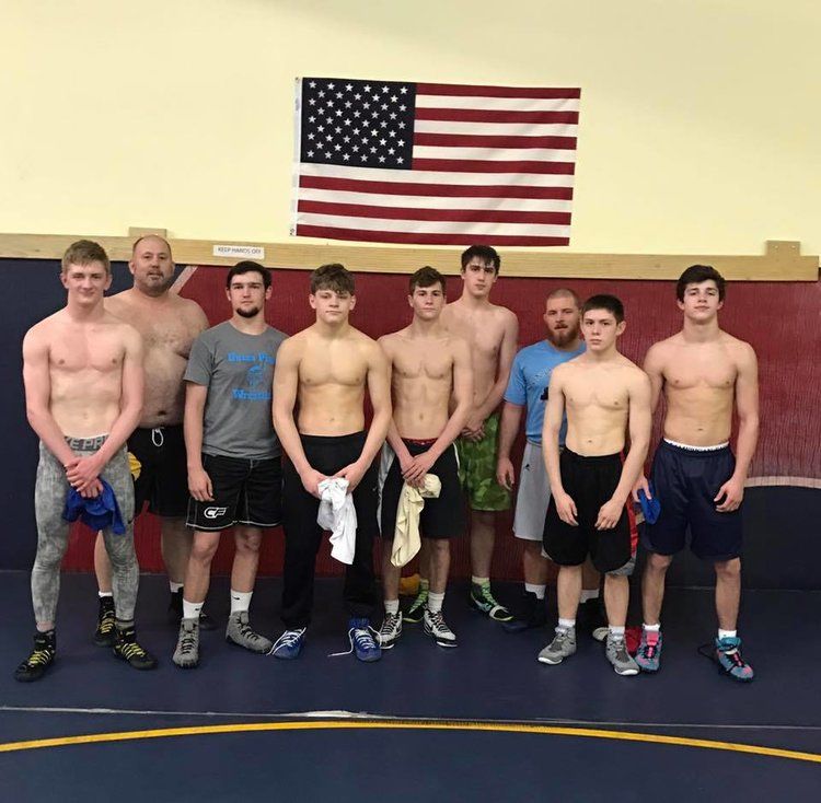 Group of wrestlers in training room.